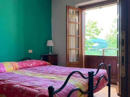 ファブリアーノにあるAgriturismo Gioie di Campagnaのベッドと大きな窓のある寝室