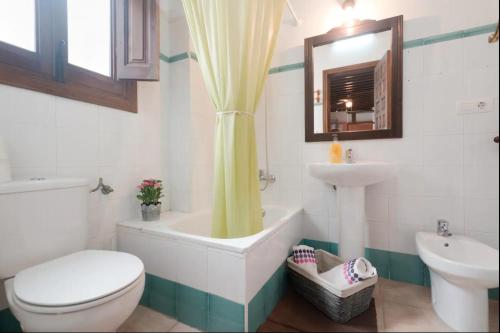 a bathroom with a tub and a toilet and a sink at Apartamentos centro historico in Granada