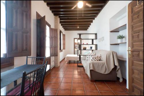 a hallway with a table and a chair in a room at Apartamentos centro historico a los pies de la Alhambra in Granada