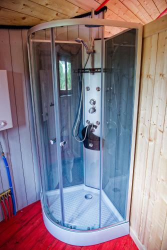 - une douche avec une enceinte en verre dans l'établissement Yourte Roulotte et Gite de la Laïta, à Clohars-Carnoët