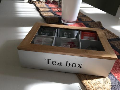 a tea box on a table with a glass of milk at Casa Verde Palmares in Godoy Cruz