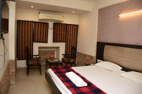 1 dormitorio con 1 cama y sala de estar con chimenea en HOTEL GOMTI, en Nagpur