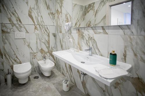 a bathroom with a sink and a toilet and a mirror at Forever Luxury Rooms in Castellammare di Stabia