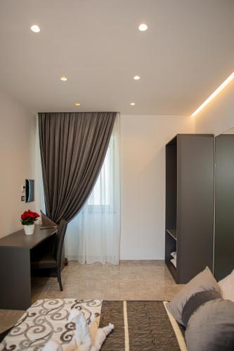 a bedroom with a bed and a desk and a window at Forever Luxury Rooms in Castellammare di Stabia
