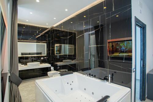 a large bathroom with a tub and a large mirror at Forever Luxury Rooms in Castellammare di Stabia