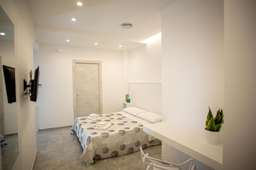 a white room with a bed and a table and a desk at Forever Luxury Rooms in Castellammare di Stabia