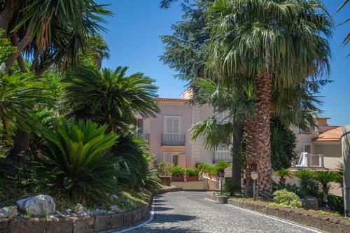 a courtyard with palm trees in front of a building at Forever Luxury Rooms in Castellammare di Stabia