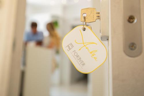 a tag on a door with people in the background at Forever Luxury Rooms in Castellammare di Stabia