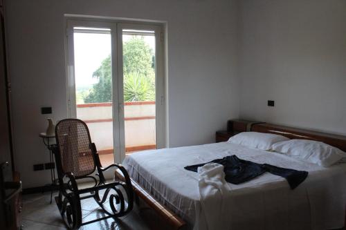 a bedroom with a bed and a chair and a window at 80 m² Vista Mare in Policastro Bussentino