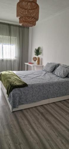 a bedroom with a large bed and a chandelier at Apartamento Santo António in Costa da Caparica