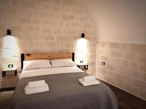 a bedroom with a large bed with two towels on it at Minuetto 16 in Ostuni
