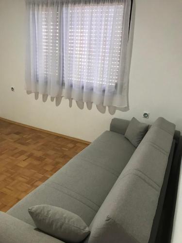 a couch in a living room with a window at Apartmani Golubina - Trn, Laktasi, BANJA LUKA in Grabljani