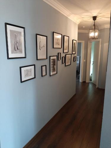 a hallway with a wall with framed pictures on it at Seeliebe mit Sauna und nur 50 mtr. bis zum Strand in Senftenberg