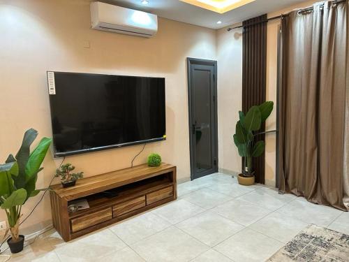 sala de estar con TV de pantalla plana en la pared en Dakar Dreams Spinelle en Dakar