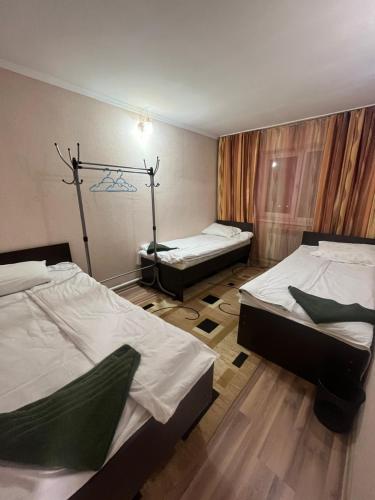 Habitación con 2 camas en una habitación con: en Jasmin, en Karakol