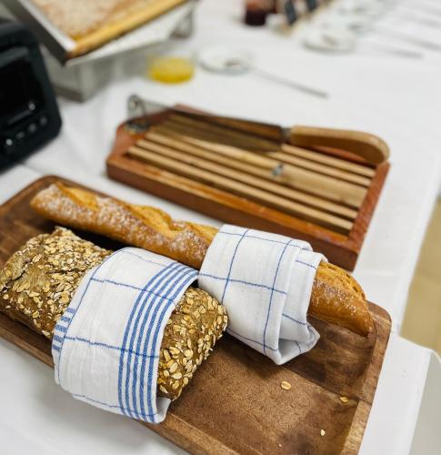 dos panes en una tabla de cortar de madera en Hotel Les Pavillons Du Golfe, en Favone