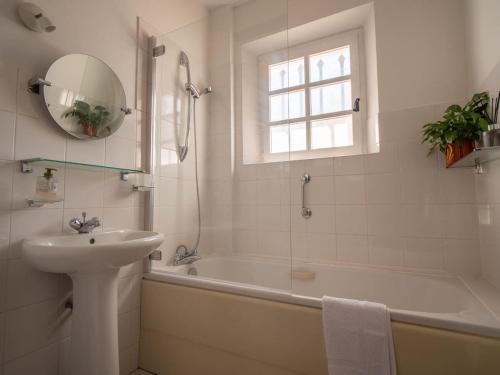 uma casa de banho com uma banheira, um lavatório e um espelho. em Résidence Les Près em La Colle-sur-Loup