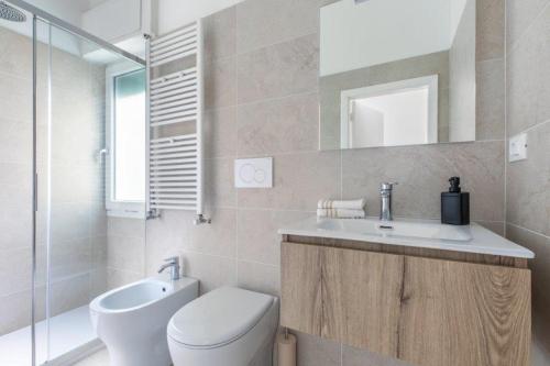 La salle de bains est pourvue de toilettes, d'un lavabo et d'un miroir. dans l'établissement House Lovely Lido Venice Beach, sur le Lido de Venise