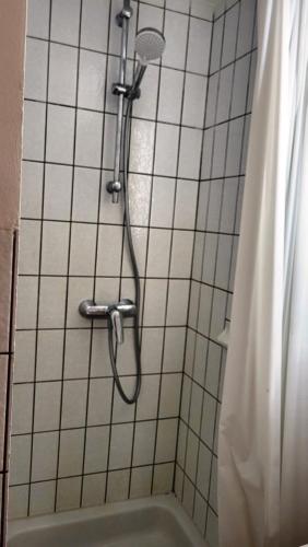 y baño alicatado con ducha y bañera. en Apartment Kliniken, en Tübingen