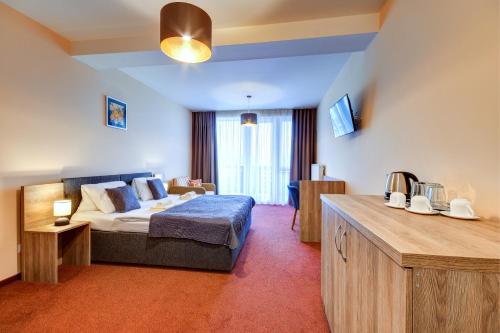 a hotel room with a bed and a table at Penzión Čerešňový Sad & Wellness in Vysoké Tatry