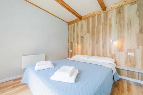 a bedroom with a blue bed with two towels on it at Villaggio Smeraldo in Moneglia
