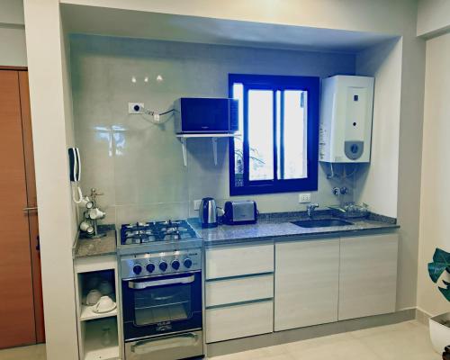 a kitchen with a stove and a sink at Aires del Norte Apart in San Miguel de Tucumán