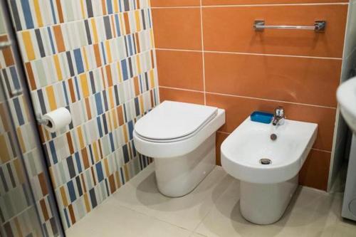 a bathroom with a toilet and a sink at ToviMar Apartments in Taormina