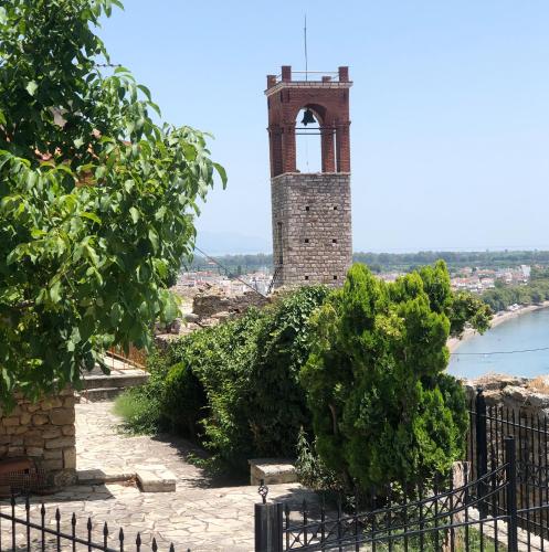 a tower with a clock on top of a building at Sideroporta castle Náfpaktos in Nafpaktos