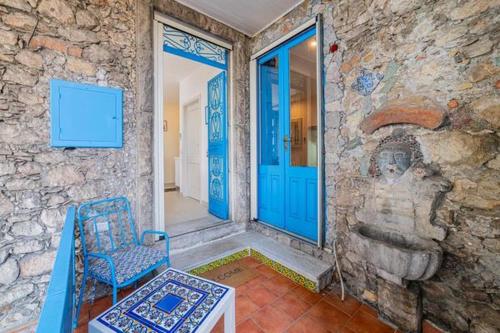 a stone house with a blue door and a chair at ToviMar Apartments in Taormina