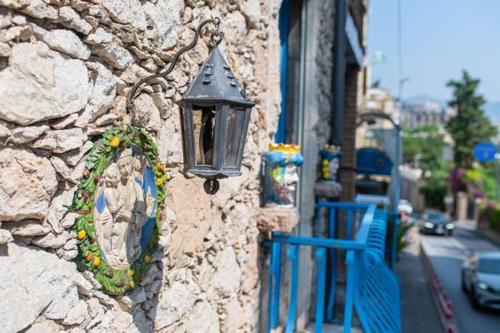 a light on the side of a stone building at ToviMar Apartments in Taormina
