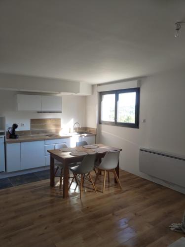 une cuisine avec une table et des chaises dans une pièce dans l'établissement Studio secteur pic Saint Loup, à Combaillaux