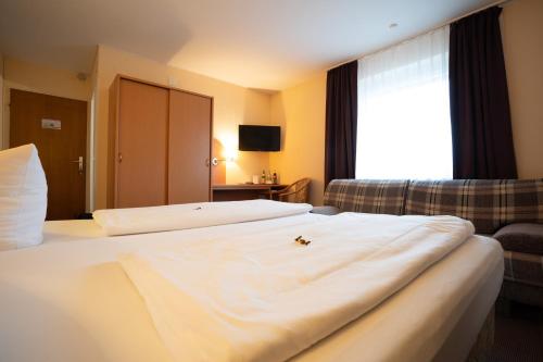 a hotel room with two beds and a couch at Hotel Zum Prinzen Sinsheim in Sinsheim