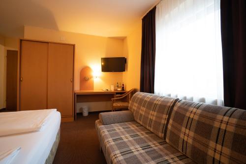 a hotel room with a couch and a desk at Hotel Zum Prinzen Sinsheim in Sinsheim