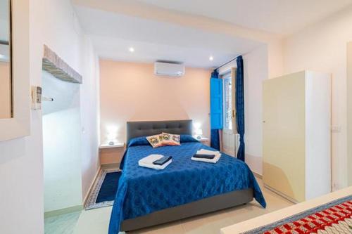a bedroom with a blue bed with two towels on it at ToviMar Apartments in Taormina
