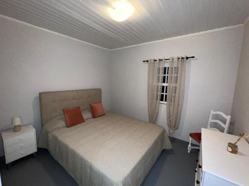 1 dormitorio con 1 cama con 2 almohadas de color naranja en Mirateca House en Madalena