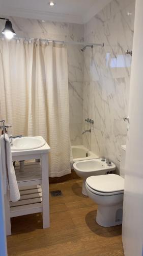 Un baño con lavabo, inodoro y bañera. en 25puntocinco deptos Tandil, en Tandil