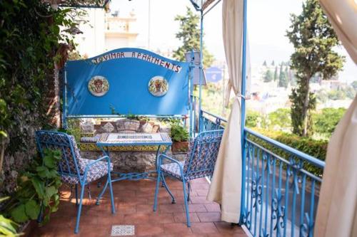 a balcony with two chairs and a table on a porch at ToviMar Apartments in Taormina