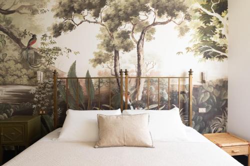 a bedroom with a bed with a mural of trees at Charming Design Apartment in Monti in Rome