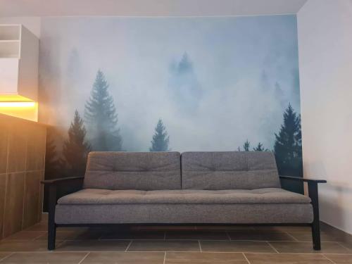 a couch in a room with a painting of trees at Tauern in Kaprun