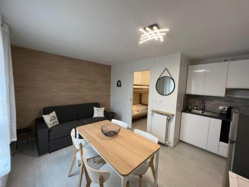 cocina y sala de estar con mesa y sofá en 4 pers, pied des pistes, WIFI, Netflix, Lave-vaisselle, en Les Deux Alpes