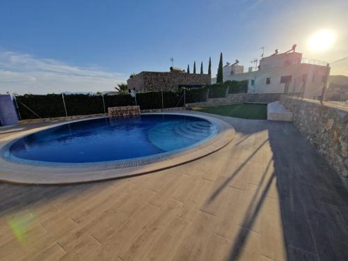 una gran piscina en una terraza de madera junto a una casa en Casa Buena Vista con piscina y ascensor en Cullera