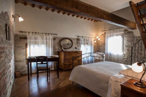 a bedroom with a bed and a desk and a table at Casale con vista sui Monti Sibillini e piscina in Amandola