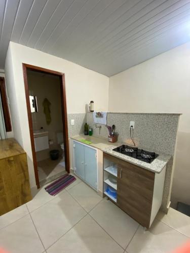 a kitchen with a stove and a counter top at Quitinete Cordeirense in Cordeiro