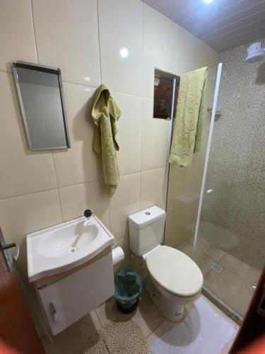 a bathroom with a toilet and a shower and a sink at Quitinete Cordeirense in Cordeiro