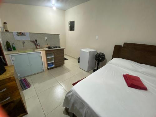1 dormitorio con 1 cama y cocina pequeña en Quitinete Cordeirense, en Cordeiro