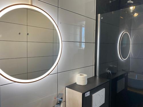 Hotel Petite Königsallee SELF CHECK-IN في دوسلدورف: حمام مع مرآة مستديرة ومغسلة