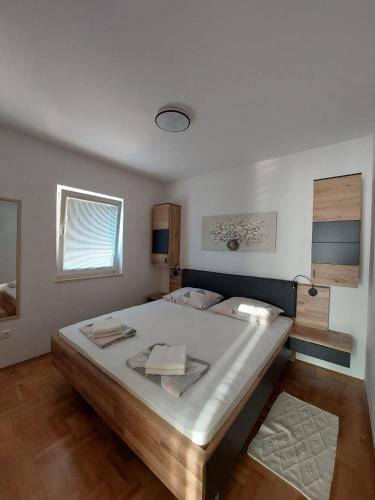 a bedroom with a large bed and a window at Apartmani Cindrić in Stara Baška
