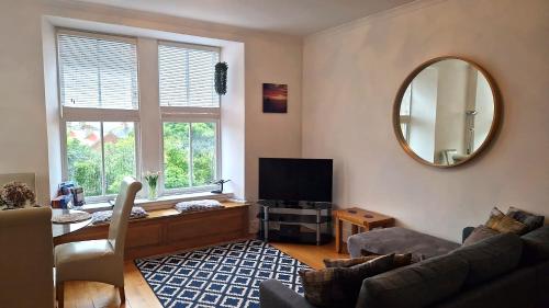 a living room with a couch and a mirror at Craigielea Apartment 3 in Lerwick
