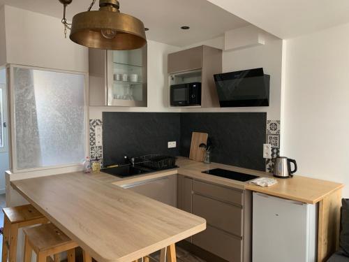 une cuisine avec un comptoir en bois et un évier dans l'établissement Cocon au cœur du village de Forcalquier, à Forcalquier