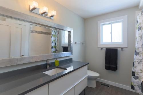 y baño con lavabo, aseo y espejo. en Boardwalk Homes Executive Suites en Kitchener